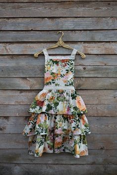 a dress hanging on a wooden wall next to a hanger with an image of flowers