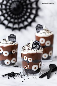 three glasses filled with chocolate pudding and sprinkles on top of a table