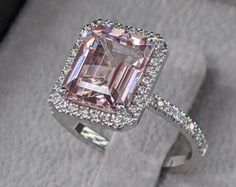 an engagement ring with a pink diamond surrounded by diamonds