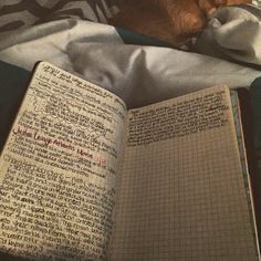 an open book sitting on top of a bed next to a dog laying in it