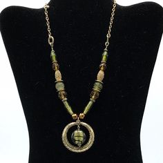 Gorgeous glass beads and brass tone necklace by Lia Sophia, green and yellow beads and large round pendant. Green Beaded Necklace With Round Pendant, Vintage Green Glass Beaded Necklaces, Green Vintage Glass Beaded Necklaces, Green Beaded Metal Necklaces, Bronze Beaded Round Necklaces, Round Bronze Beaded Necklaces, Green Necklaces With Gold Beads For Jewelry Making, Vintage Green Pendant Beaded Necklace, Green Glass Beaded Necklace With Large Beads