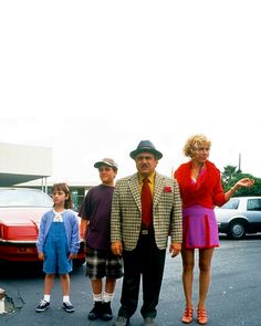 a man and two children are standing in the parking lot