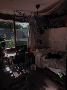 a bedroom with a bed, desk and window in the dark night time light from outside