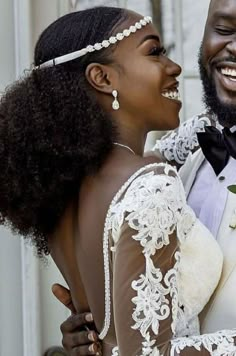 a man in a tuxedo and a woman in a wedding dress smile at each other