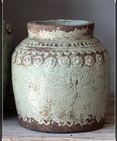 two vases sitting next to each other on a shelf