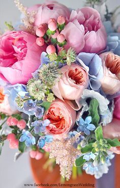 a vase filled with lots of pink and blue flowers