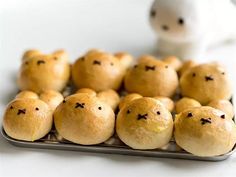 small buns are arranged on a metal tray with a white bunny in the background