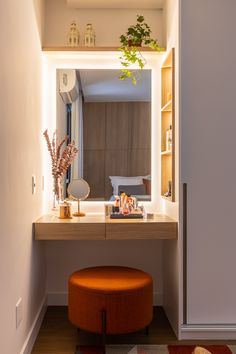 a small vanity with a stool and mirror in a room that is lit up by lights