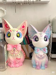 two little cat figurines sitting next to each other