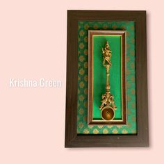 a green and gold frame with a golden bell in it on a pink background that says krishna green