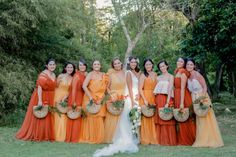 a group of women standing next to each other in front of some trees and grass