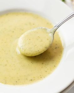 a spoon full of broth in a white bowl