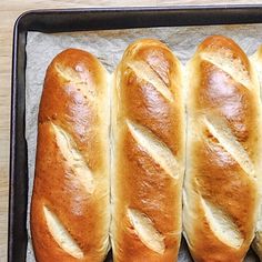 four loaves of bread sitting on top of a pan