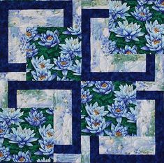 a blue and white quilt with flowers on the front, along with squares in the middle