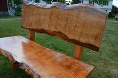 a wooden bench sitting on top of a lush green field