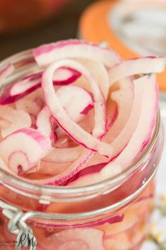 a jar filled with pickled onions on top of a table