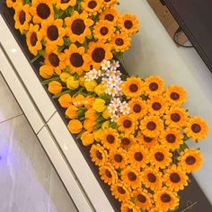 sunflowers and daisies are arranged on the floor