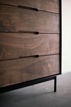 a close up of a wooden dresser with black handles and drawers on it's sides