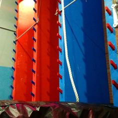 there are many different colored ropes on the wall and one is red, white, and blue