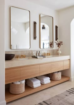 a bathroom with two sinks, mirrors and towels on the counter top in front of it