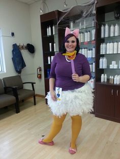 a woman in a costume holding a toothbrush and standing on a hard wood floor