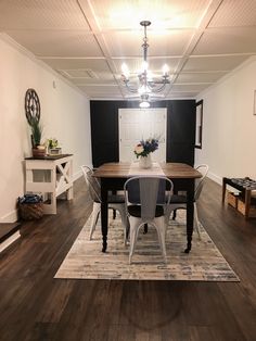 a dining room table with chairs and a rug on the floor