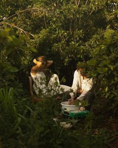 two people sitting in the woods with buckets