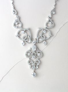 In silver rhodium plating this crystal bridal necklace is truly beautiful ! Scrolls upon scrolls of Swarovski Pure Brilliance cubic zirconia encrusted elegance. At the center of the necklace is a beautiful oval cz stone surrounded by small cz stones. This necklace is perfect for any special occasion gown. Necklace measures 18 inches and comes with 2 inch extension chain. LISTING IS FOR NECKLACE ONLY MATCHING PIECES: https://www.etsy.com/listing/252455207/crystal-bridal-earrings-chandelier https: Elegant White Gold Rhinestone Necklace For Wedding, Exquisite Silver Bridal Necklace With Elegant Design, Dazzling Crystal Bridal Necklace With Intricate Design, Dazzling Bridal Crystal Necklace With Intricate Design, Elegant White Gold Bridal Necklace With Crystal, Elegant White Gold Crystal Bridal Necklace, White Gold Bridal Necklace With Elegant Crystal Design, Elegant Sterling Silver Rhinestone Necklace For Wedding, Wedding Necklace With Intricate Crystal Design