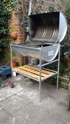 an outdoor bbq grill sitting on top of a wooden bench next to a brick wall