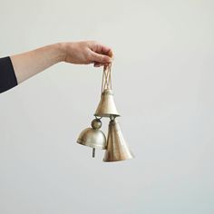 two bells being held by someone's hand