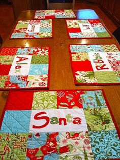 the table runner is made with red, green and blue quilted squares that spell out santa