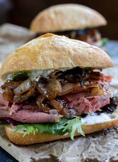 a sandwich with meat, onions and lettuce on it