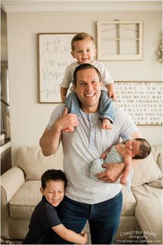 a man is holding two small children and posing for the camera