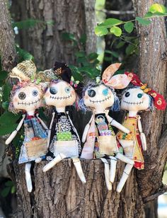 three dolls sitting on top of a tree