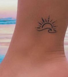 a small sun and wave tattoo on the side of a woman's foot,