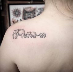 an elephant family tattoo on the back of a woman's upper arm and shoulder