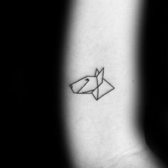 a black and white photo of a small tattoo on the left inner arm with an origami fish in it