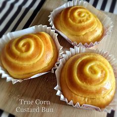 three cupcakes sitting on top of a wooden cutting board