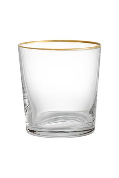 an empty glass with gold rim sitting on a white surface