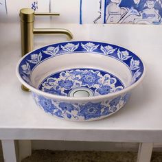 a blue and white bowl sink sitting on top of a counter next to a faucet