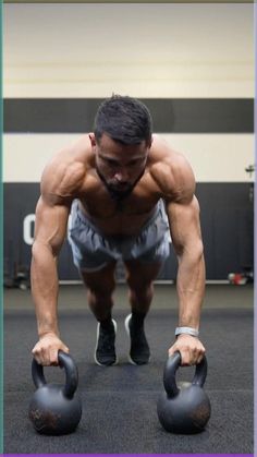 a man doing push ups with two kettles