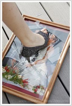 a woman's foot is sticking out of a photo in a wooden frame on the ground