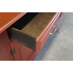 an open drawer on top of a red cabinet