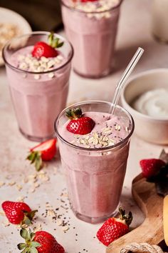 two glasses filled with smoothie and topped with strawberries