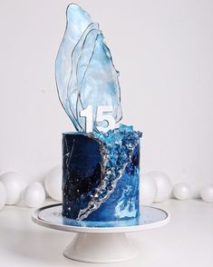 a blue and white marbled cake with the number fifteen on it's side