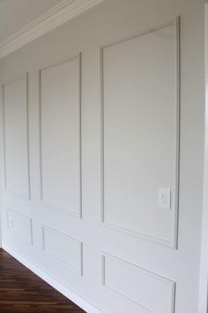 an empty room with white walls and wood flooring on either side of the wall