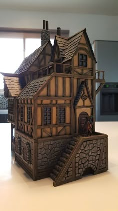 a wooden model of a house sitting on top of a table