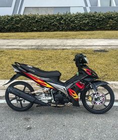 a red and black motorcycle parked on the street