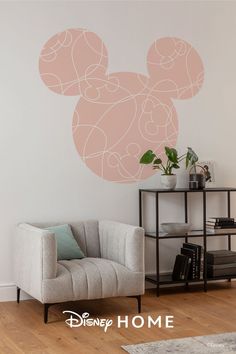 a living room with a mickey mouse decal on the wall and a chair in front of it