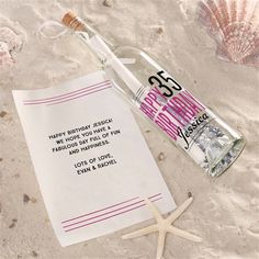 a message in a bottle on the beach next to a starfish and seashell